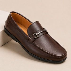 Home StepCraft Elite Comfort Loafers – Sophistication in Every Step Designed for men who appreciate timeless style and unmatched comfort, the StepCraft Elite Comfort Loafers combine premium craftsmanship with modern functionality. Whether you're heading to the office, attending a formal event, or enjoying a casual evening out, these loafers offer a polished appearance while keeping your feet comfortable all day long. Crafted with a high-quality premium synthetic leather upper, these loafers feature a sleek slip-on design for easy wear and a sophisticated finish that complements both formal and casual outfits. The soft cushioned footbed provides excellent support and absorbs pressure, making every step feel effortless. The breathable inner lining promotes airflow to keep your feet cool and fresh throughout the day, while the lightweight construction minimizes fatigue during long hours of wear. A flexible anti-slip rubber outsole ensures dependable traction and stability on various surfaces, giving you confidence wherever you go. With their refined silhouette and versatile design, the StepCraft Elite Comfort Loafers pair perfectly with formal trousers, chinos, jeans, blazers, kurtas, and smart-casual attire. Whether it's a boardroom meeting, festive celebration, wedding, dinner date, or weekend outing, these loafers are built to match every occasion.